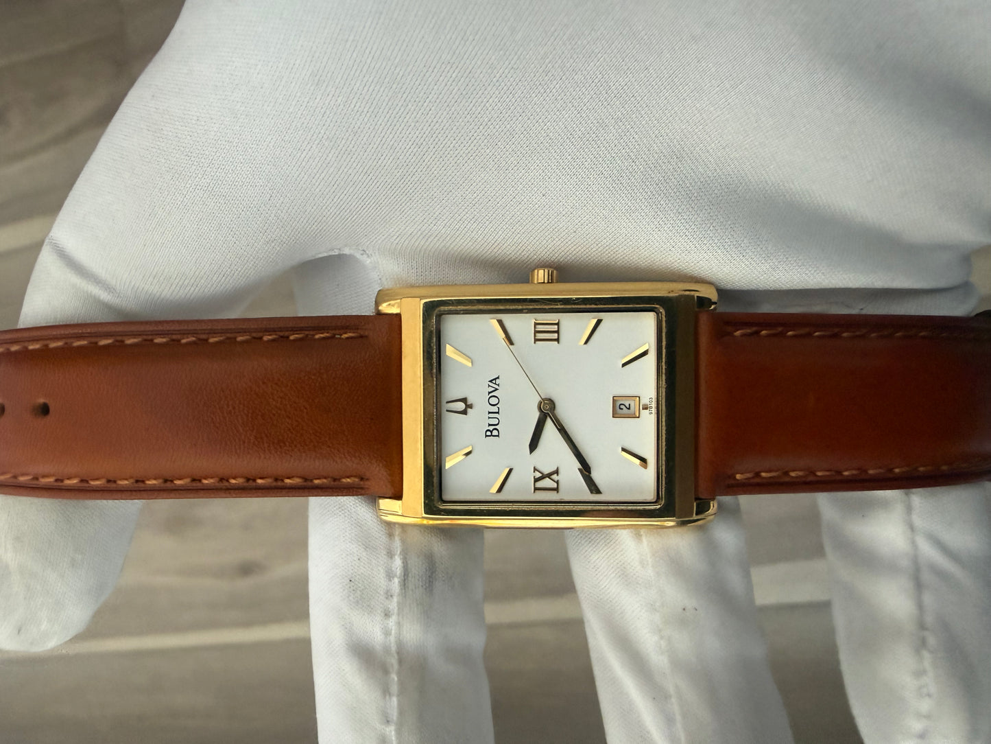Bulova rectangular dress watch, gold-tone case on a leather strap, quartz movement